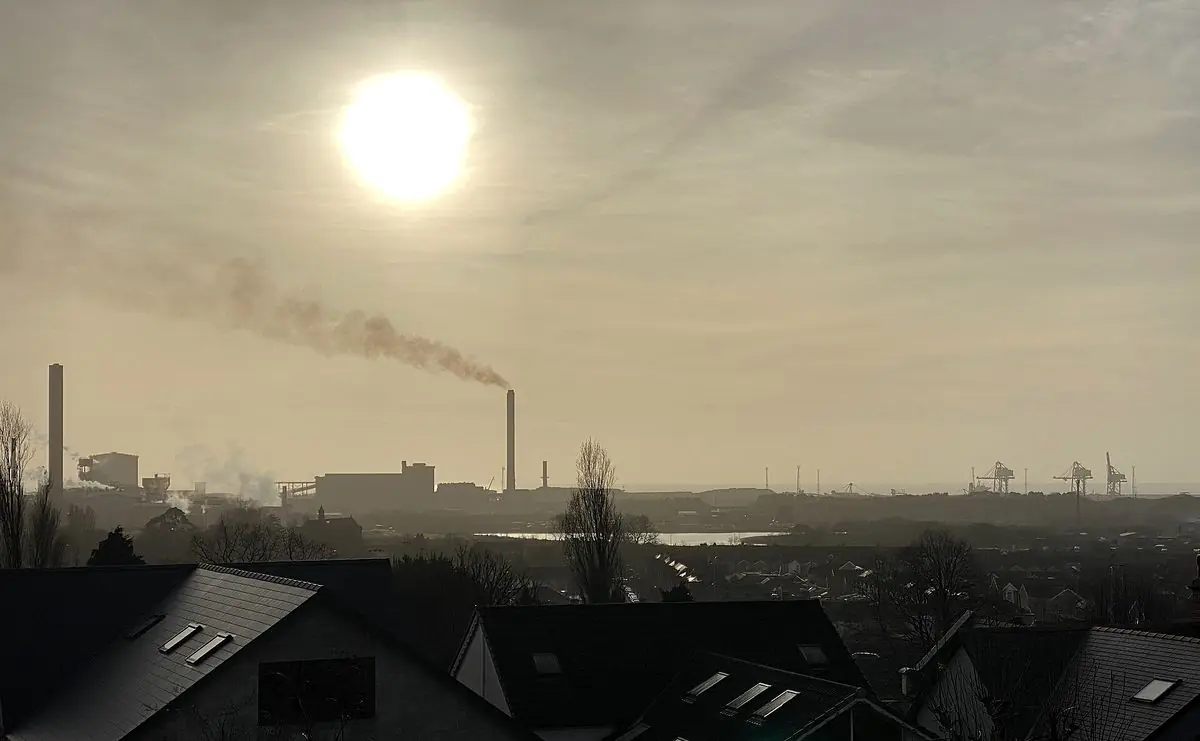 A hazy sun above Port Talbot steelworks and the rooftops of the town